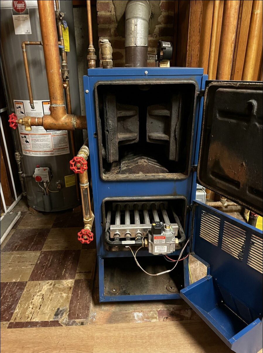 Older gas furnace opened for inspection and burner service