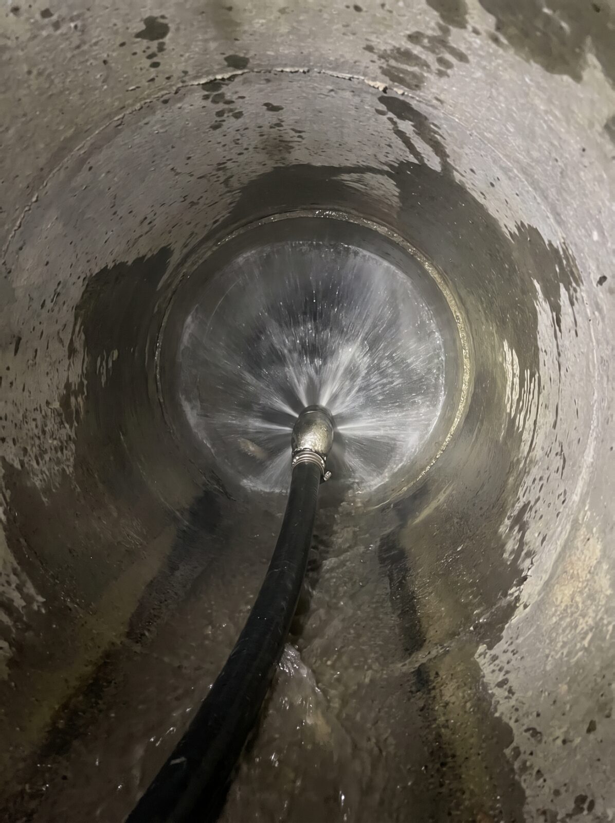 High pressure water jet cleaning grease and scale from a drain pipe