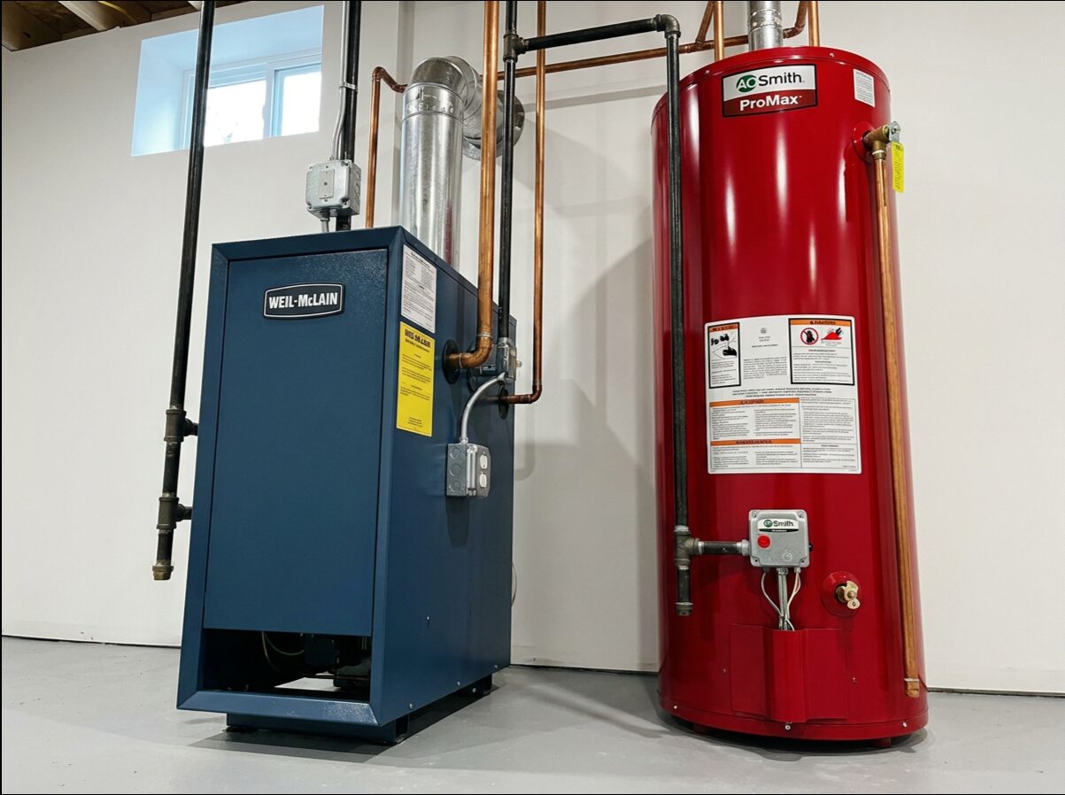 Oil-fired boiler installed next to a red oil storage tank