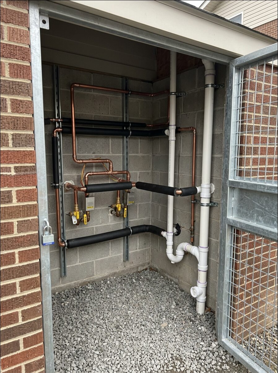 Exterior water service line piping entering a building wall