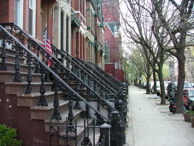 Brownstone row houses with stoops on a Jersey City street