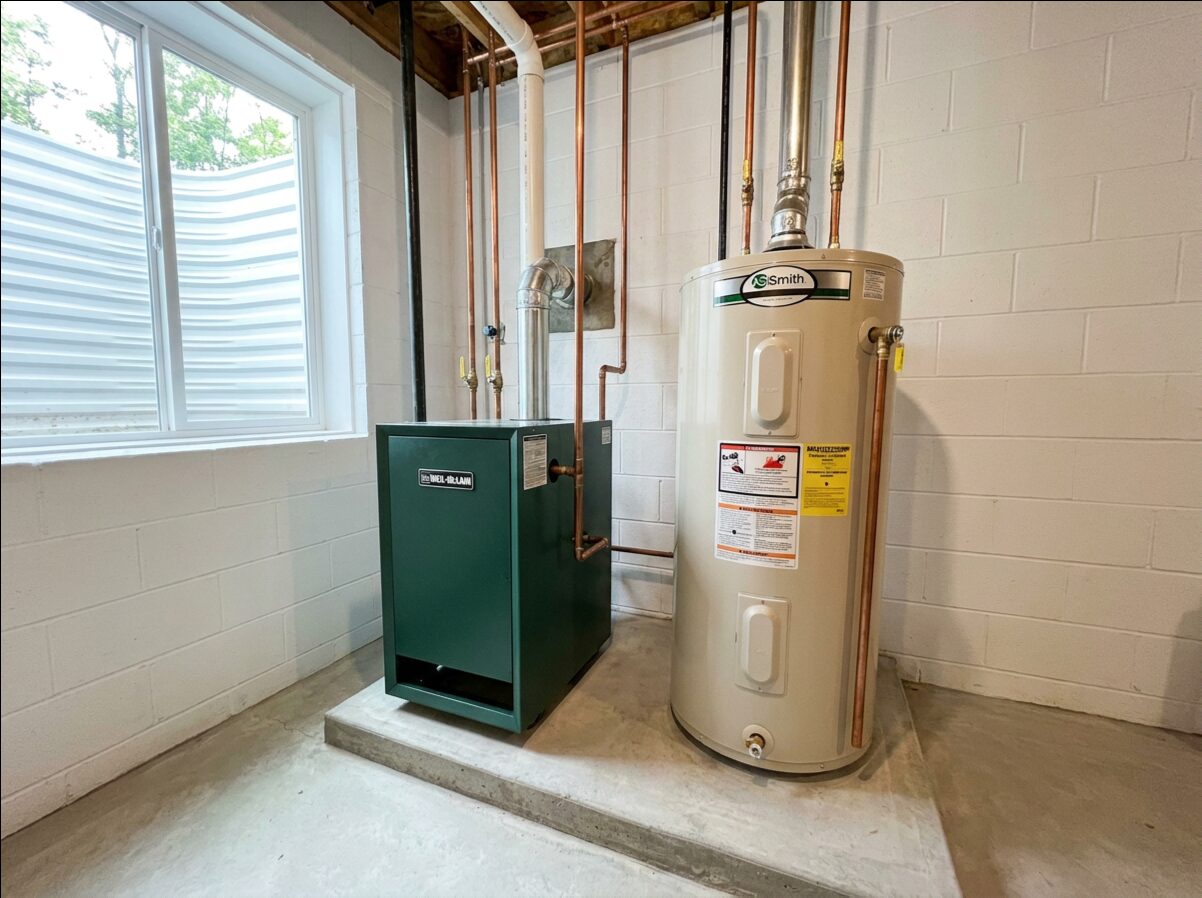 Boiler and water heater installed side by side in a finished basement